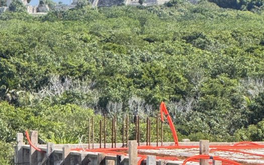 Tulum real estate market 2026 — construction at El Mirador with Maya ruins in background, Zona Arqueológica, Tulum Mexico