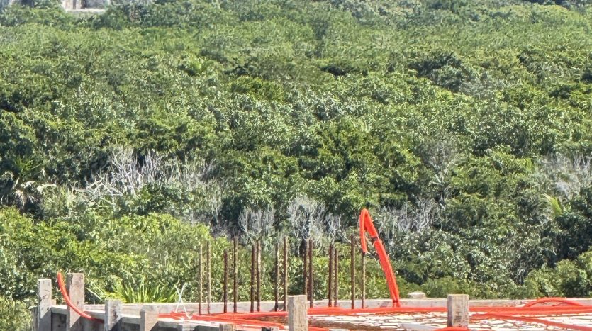 Tulum real estate market 2026 — construction at El Mirador with Maya ruins in background, Zona Arqueológica, Tulum Mexico