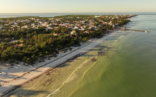 Aerial drone view of Holbox town and beach at golden hour, showing Holbox real estate infrastructure