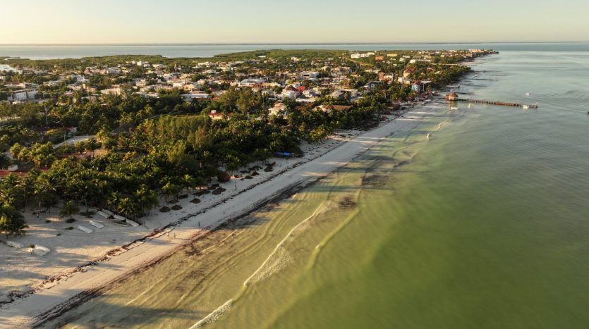 Aerial drone view of Holbox town and beach at golden hour, showing Holbox real estate infrastructure